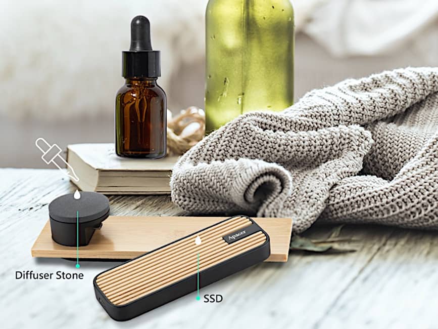 El Apacer AS712 SSD con Perfume junto a su piedra difusora y un aceite esencial, mostrando su característica aromática.