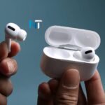Una persona sosteniendo los nuevos Apple AirPods Pro 3 blancos, mostrando uno fuera de su estuche de carga abierto.