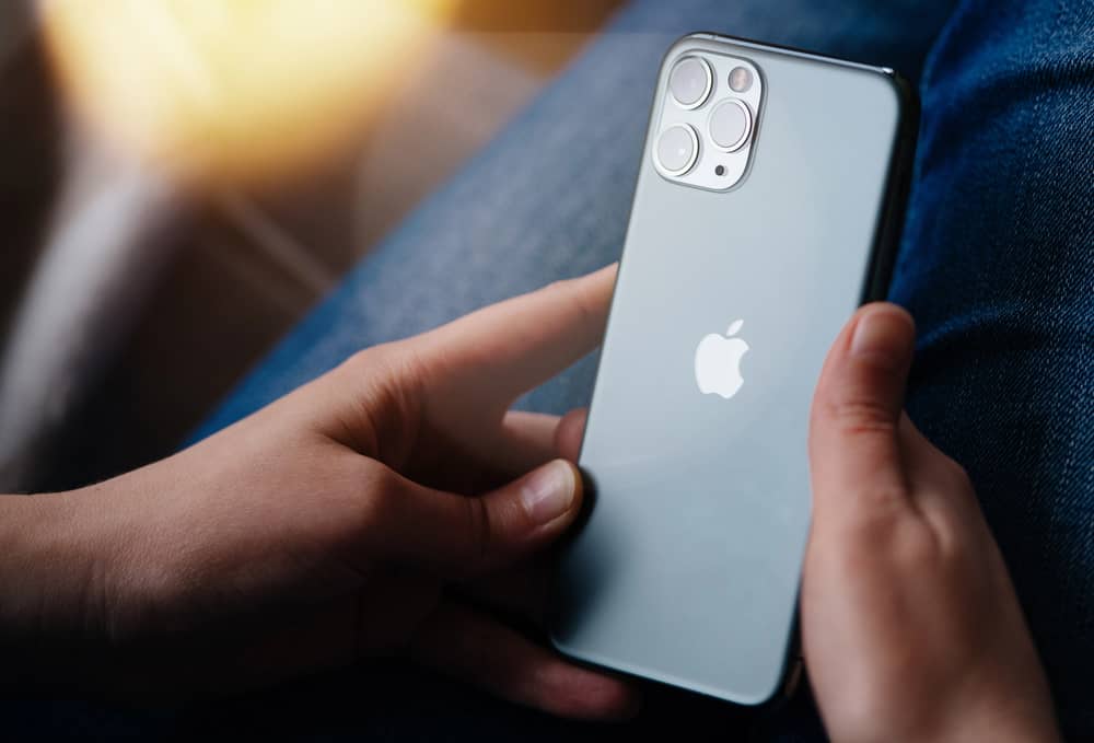 Manos sosteniendo un iPhone 11 Pro, fundamental para considerar si es el modelo adecuado o qué iPhone elegir para una actualización compatible.