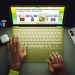Vista superior del nuevo MacBook Neo en uso sobre un escritorio junto a otros dispositivos Apple